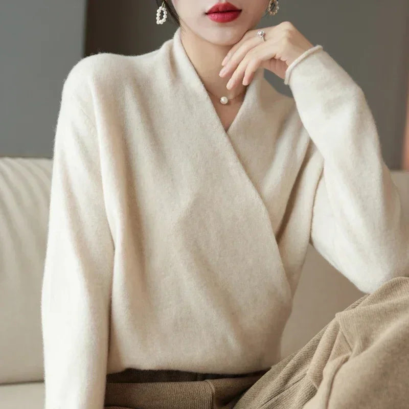 Woman in soft cream knit sweater and beige pants sitting on sofa, Rovelli fashion