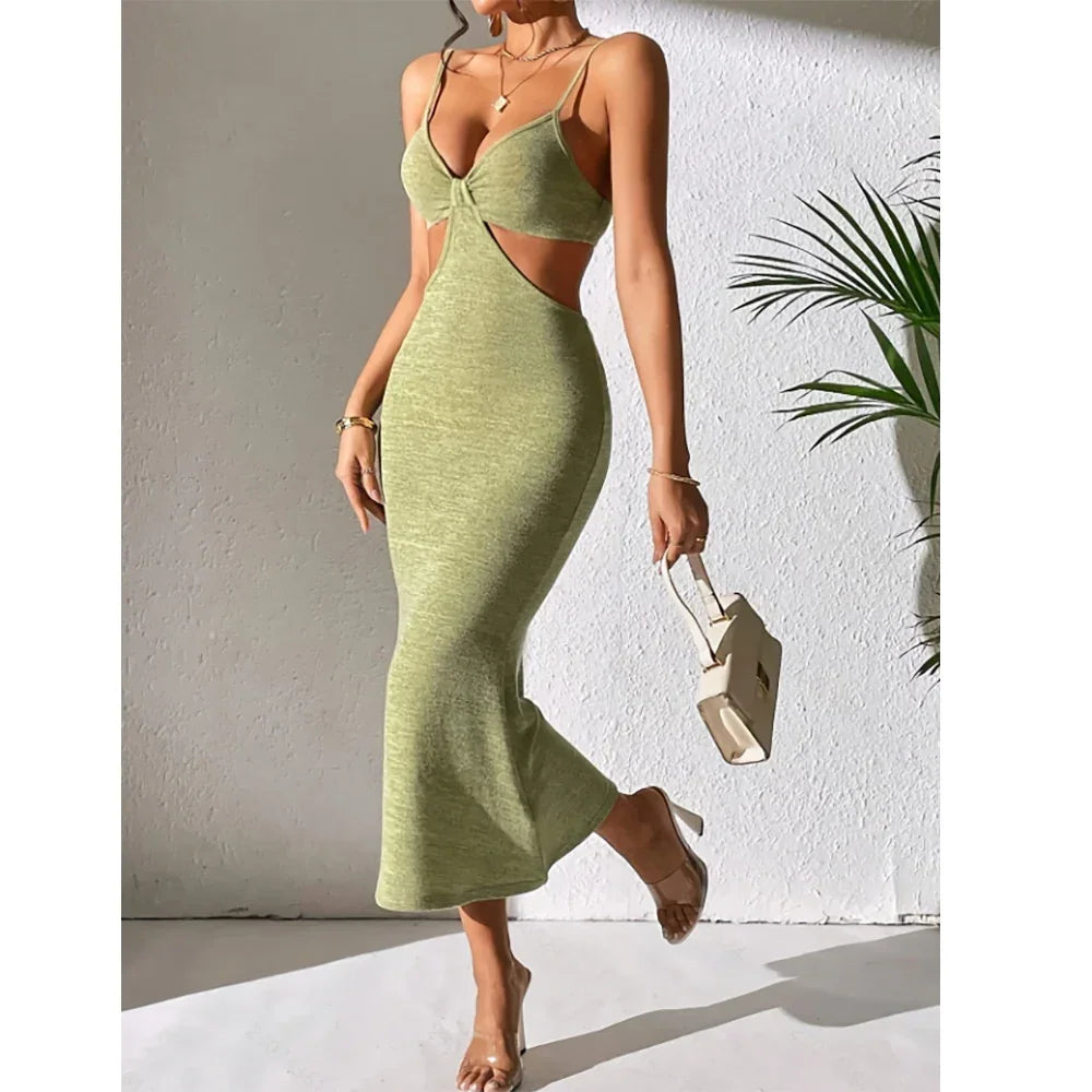Woman wearing green cutout midi dress with spaghetti straps, holding beige handbag, Rovelli