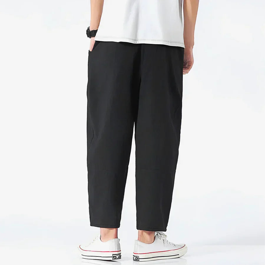 Rovelli relaxed fit black cropped pants, back view, styled with white sneakers