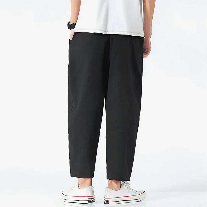 Rovelli relaxed fit black cropped pants, back view, styled with white sneakers