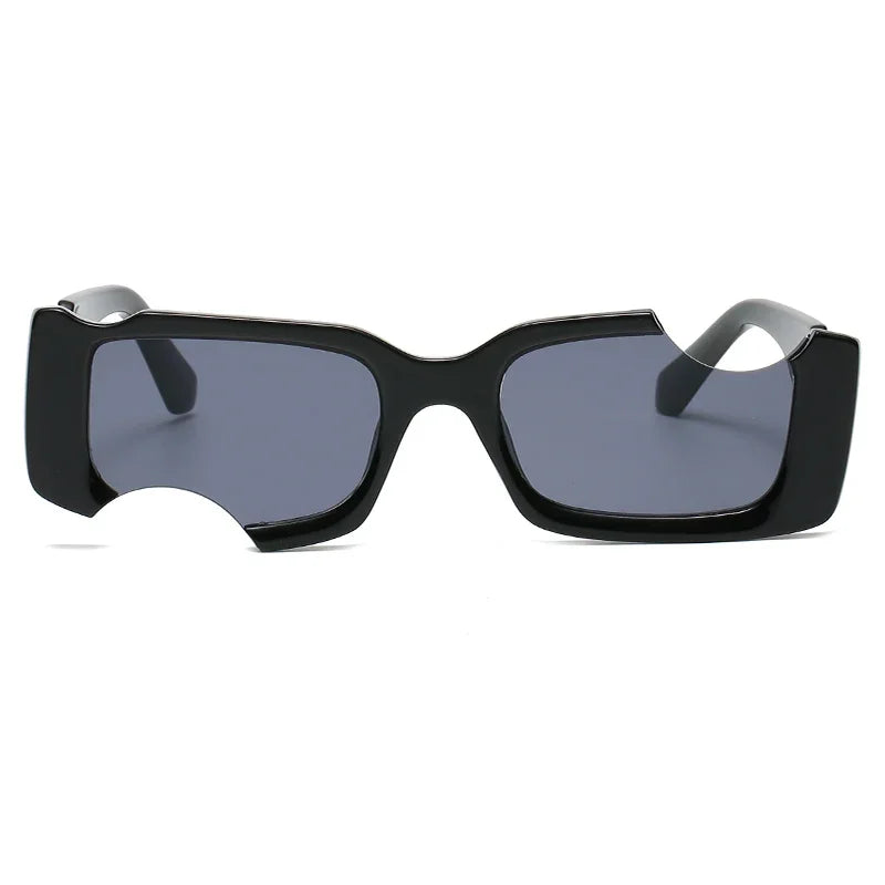 A pair of rectangular black sunglasses with dark lenses, featuring a distinctive cut-out notch on the lower left side of the frame—perfect for elevating your street style with bold geometric frames.