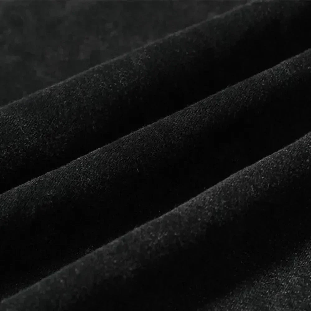 Close-up of black velvet fabric with soft texture, showing ridges and folds that highlight its smooth, luxurious surface—ideal for graphic design projects or pairing with an oversized fit.
