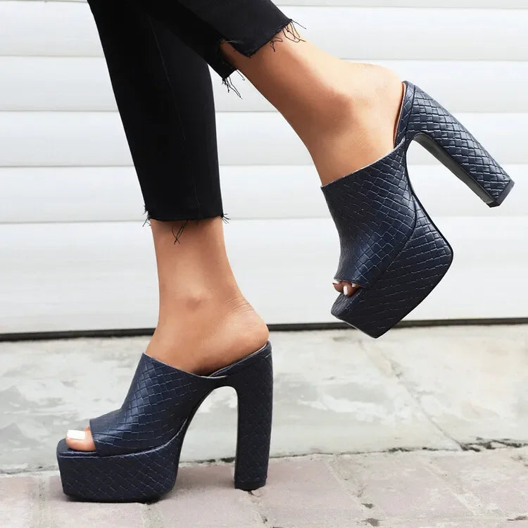 Woman wearing black woven platform high heel mules by Rovelli, outdoor fashion footwear