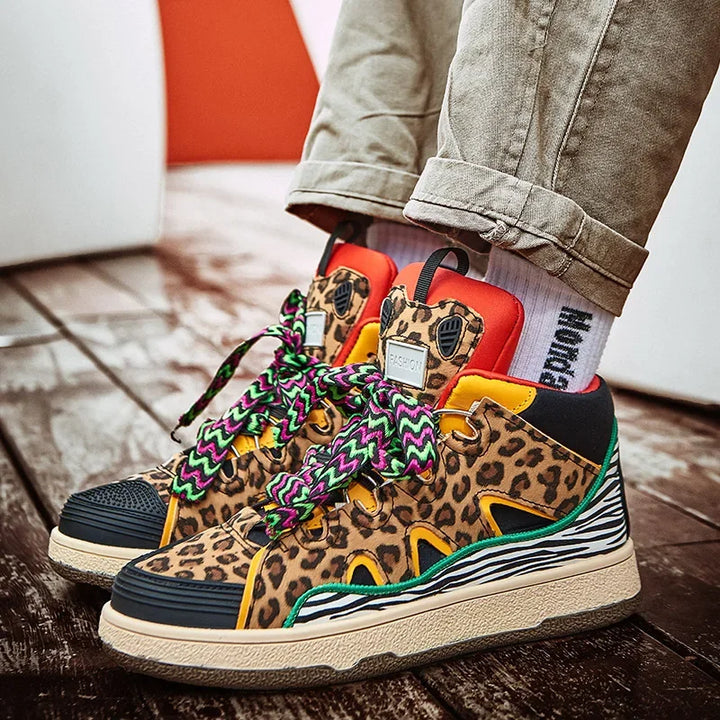 Close-up of a person wearing rolled-up khaki pants and animal print shoes with thick zigzag laces, zebra-striped, durable rubber soles, and white socks featuring bold graphics, standing on wooden flooring.