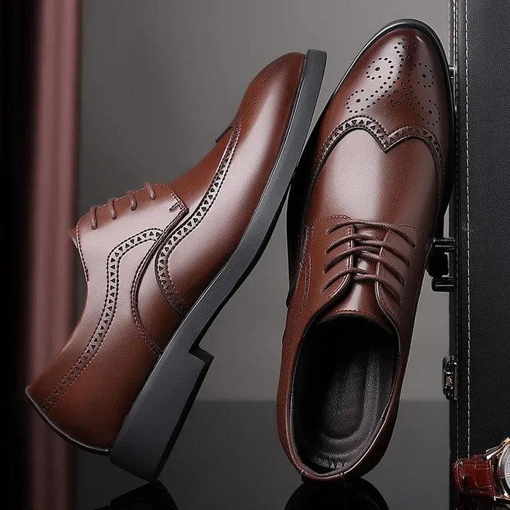 A pair of premium leather shoes with brogue detailing, black soles, and laces, displayed against a dark background—one upright and the other lying on its side.
