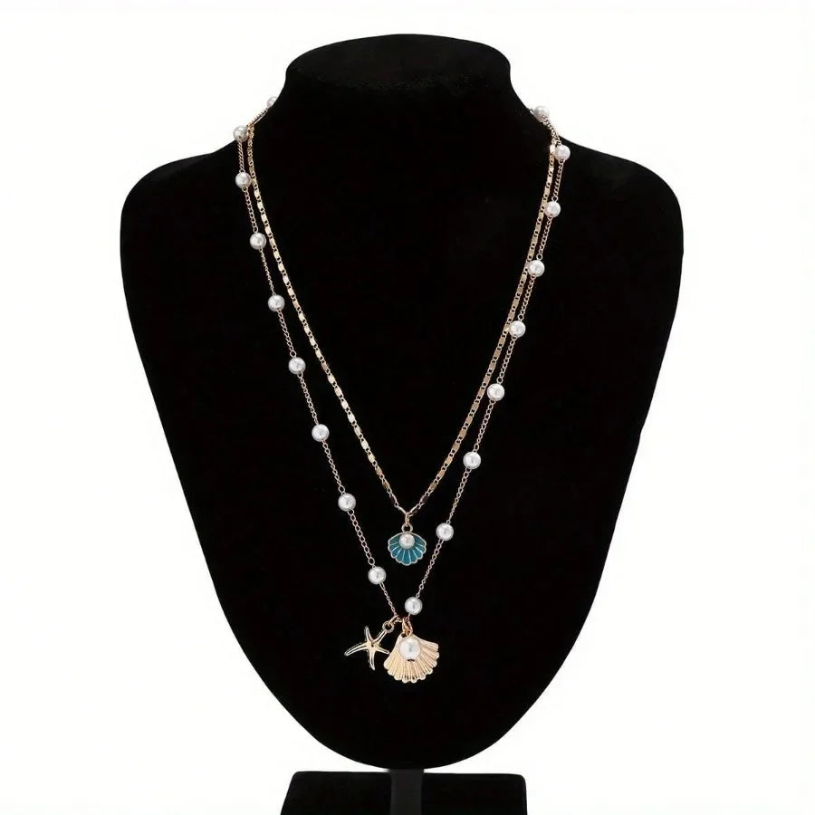 Rovelli layered pearl necklace with shell and starfish pendants on black display bust