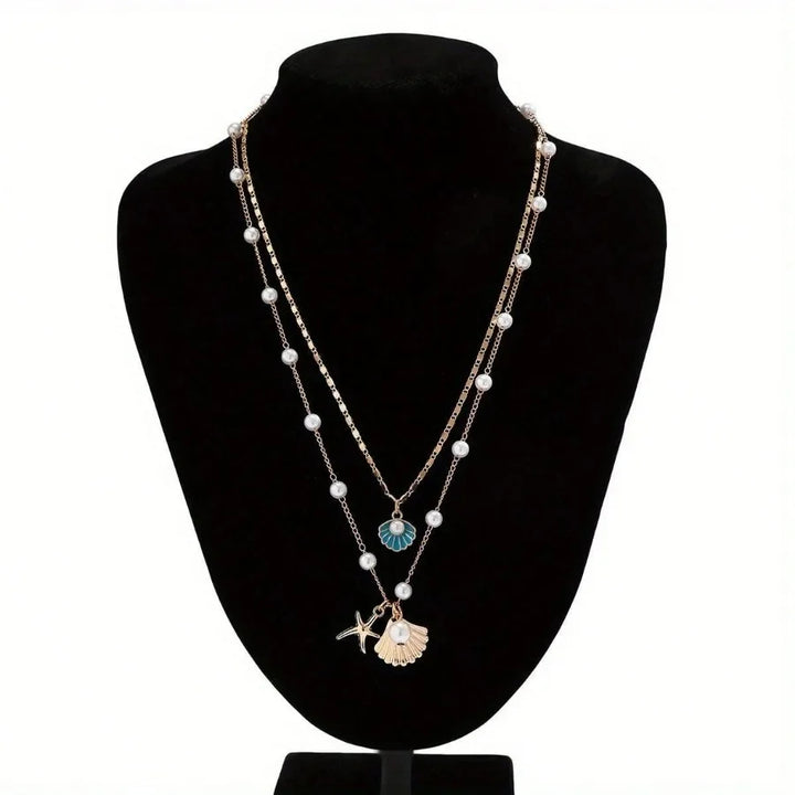 Rovelli layered pearl necklace with shell and starfish pendants on black display bust