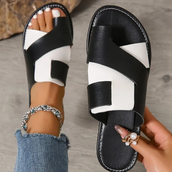 Rovelli black and white crisscross flat sandals on foot, casual fashion style