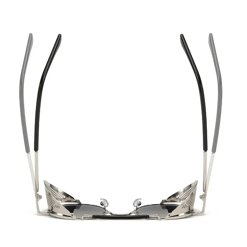 A pair of Steampunk sunglasses viewed from the front with the arms raised, showing silver frames, black tips, and reflective lenses. The design appears futuristic and angular with bold metallic vibes.