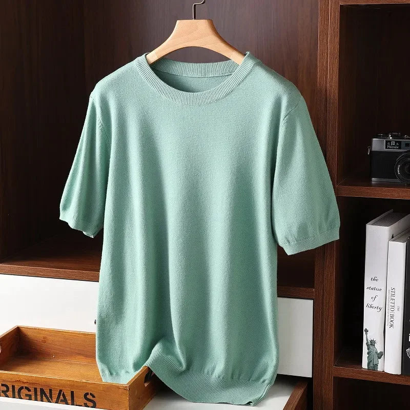 Mint green knit short sleeve sweater by Rovelli on wooden hanger in modern shelf