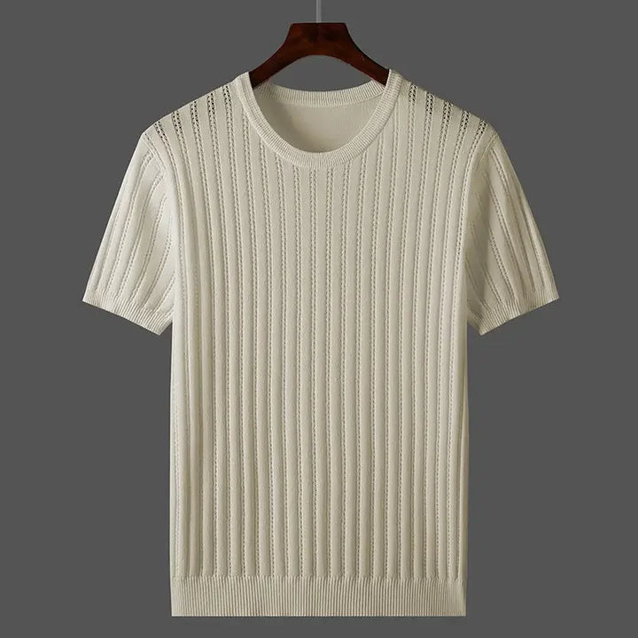 Short-sleeve, cream-colored knit sweater with vertical ribbed and cable patterns in a classic fit, displayed on a wooden hanger against a gray background.