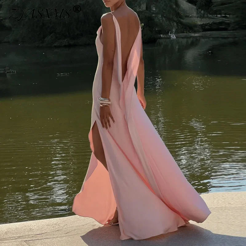 Woman in elegant pink backless maxi dress by lake, Rovelli fashion style