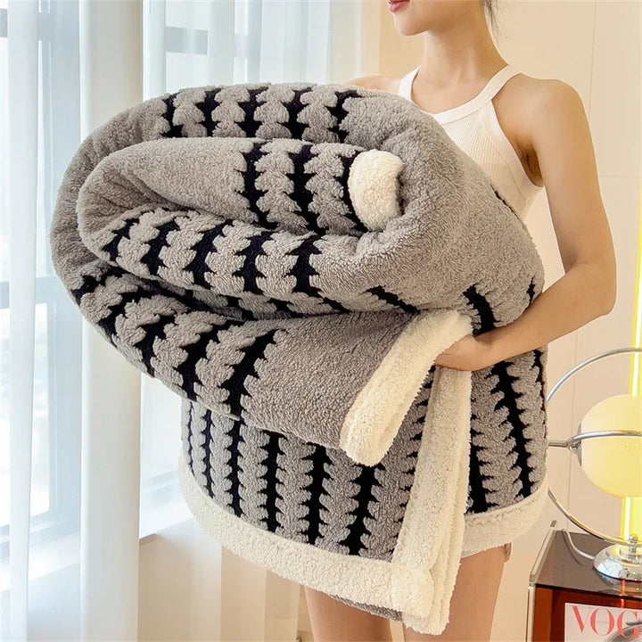 Woman holding a large grey and black sherpa blanket, Rovelli home decor setting