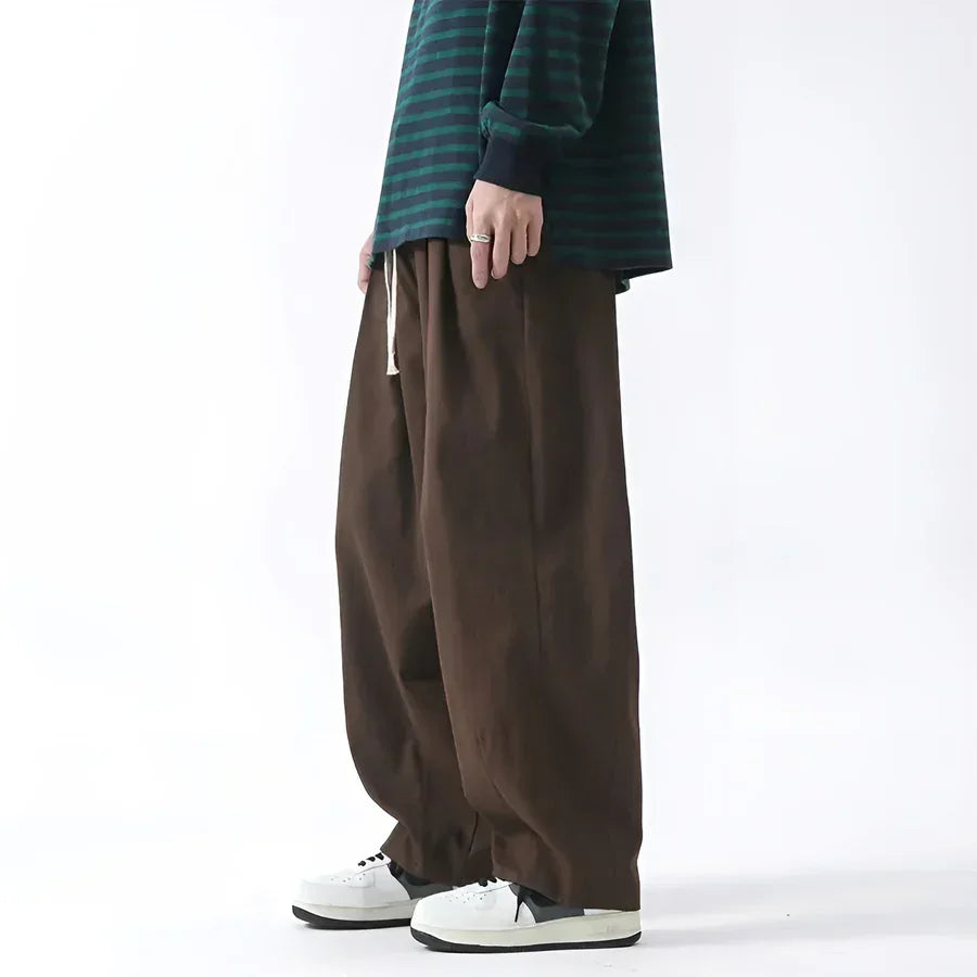 Rovelli wide-leg brown pants paired with a green striped shirt and white sneakers