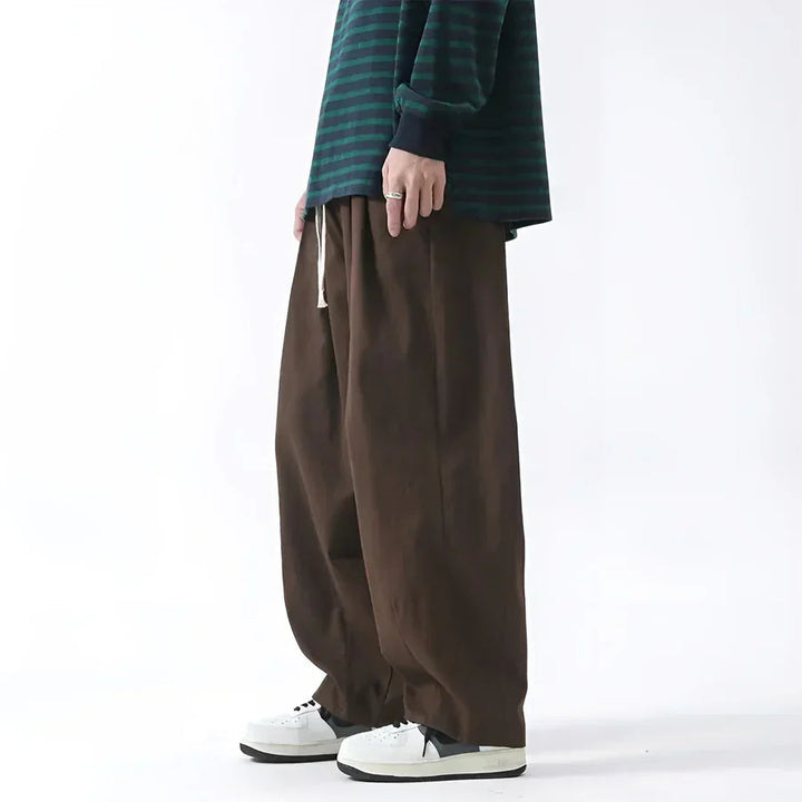 Rovelli wide-leg brown pants paired with a green striped shirt and white sneakers