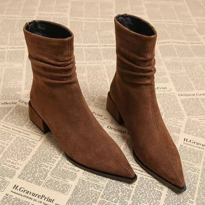 Brown suede pointed-toe ankle boots with block heel on newspaper background, Rovelli fashion
