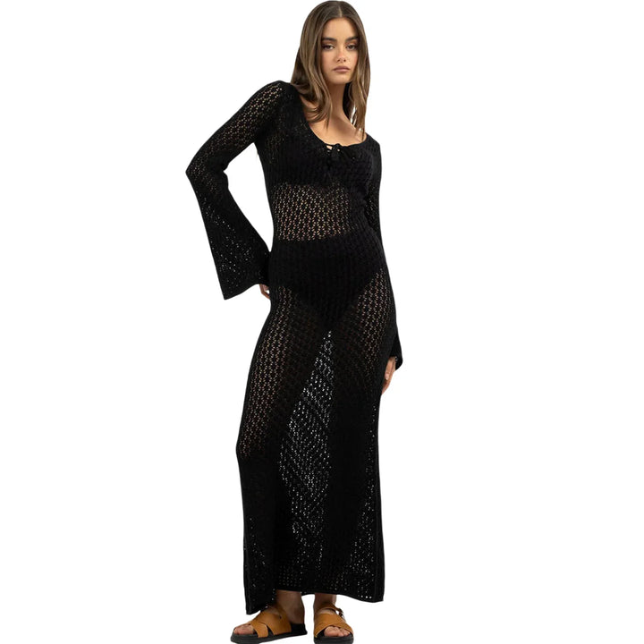 Woman wearing a black crochet long-sleeve maxi dress with sandals from Rovelli