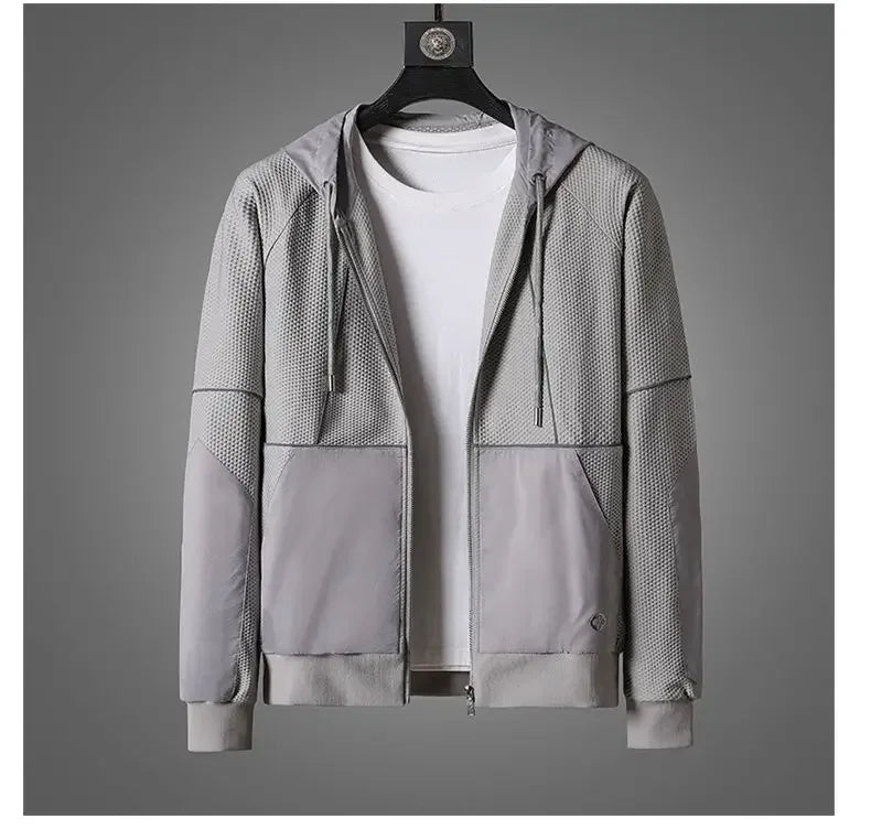 A light gray zipper hoodie with mesh-textured panels and moisture wicking fabric is displayed on a hanger over a plain white T-shirt, set against a neutral gray background.