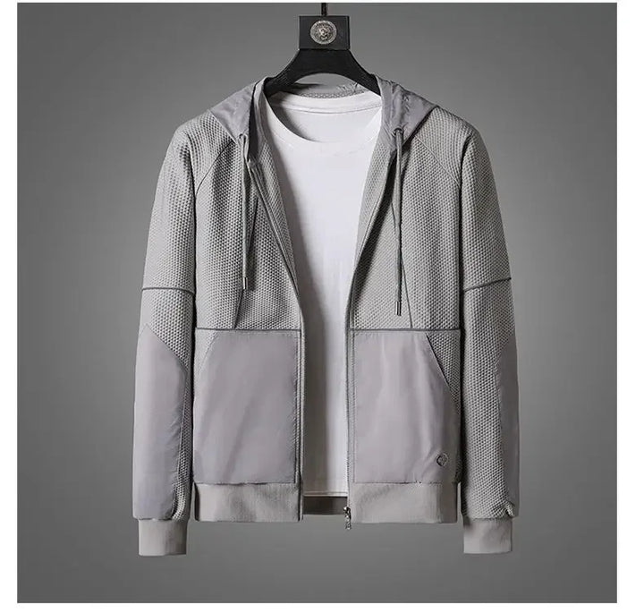 A light gray zipper hoodie with mesh-textured panels and moisture wicking fabric is displayed on a hanger over a plain white T-shirt, set against a neutral gray background.