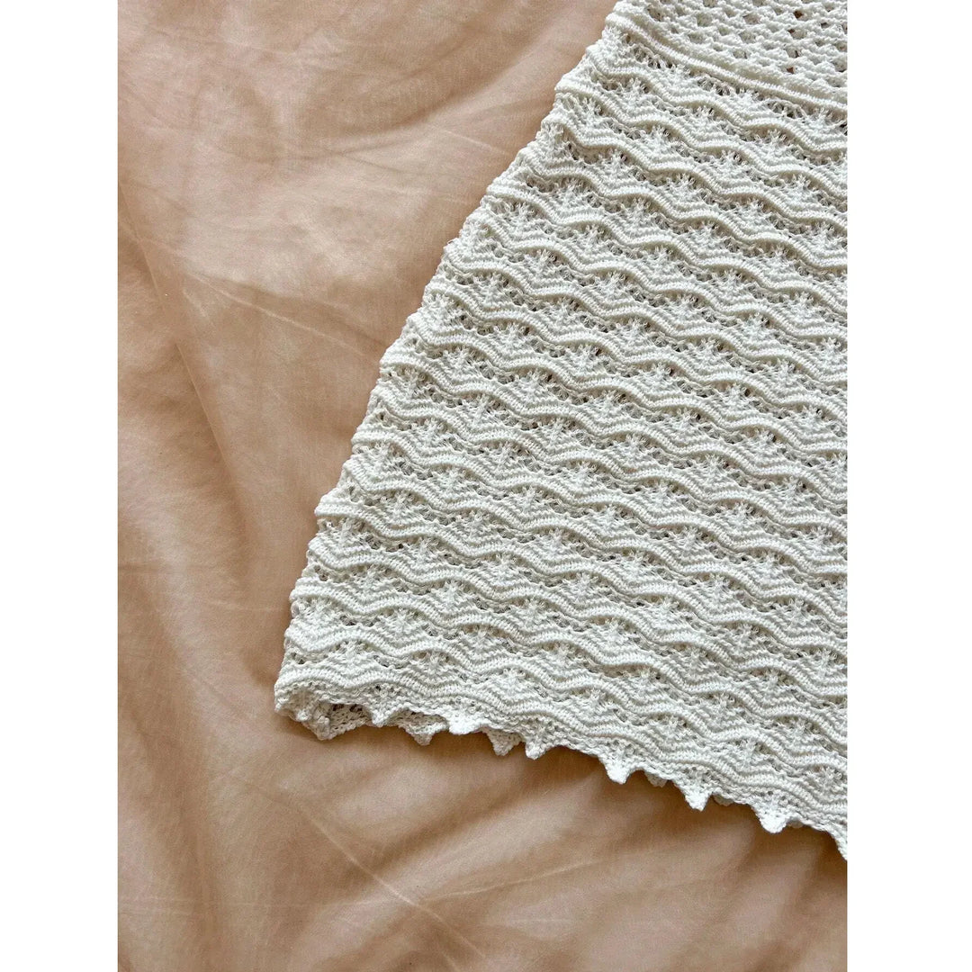 Rovelli cream crochet skirt with wavy textured pattern on beige fabric background