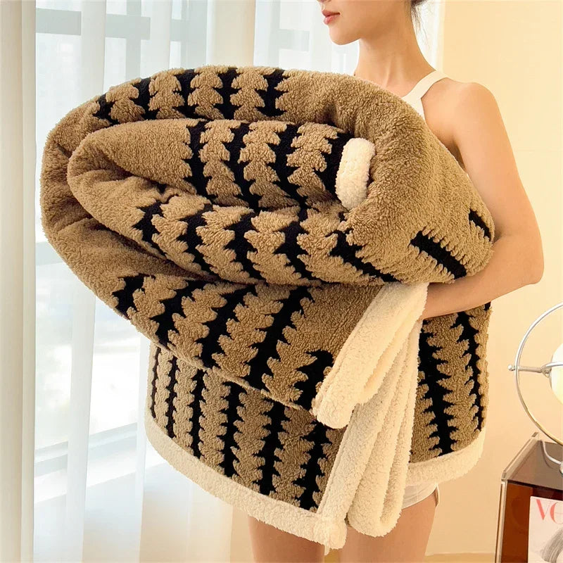 Woman holding a large, soft brown and black patterned blanket near a window, Rovelli home textile