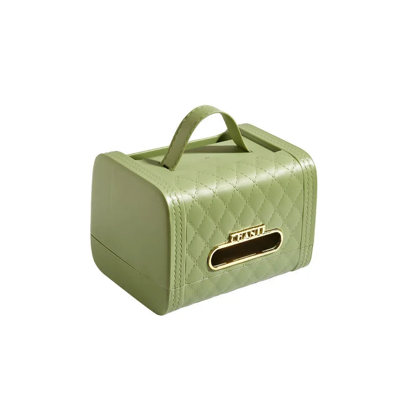 A green, quilted rectangular tissue box holder with a handle on top and a gold-edged opening for dispensing tissues—this stylish storage solution doubles as elegant home decor.