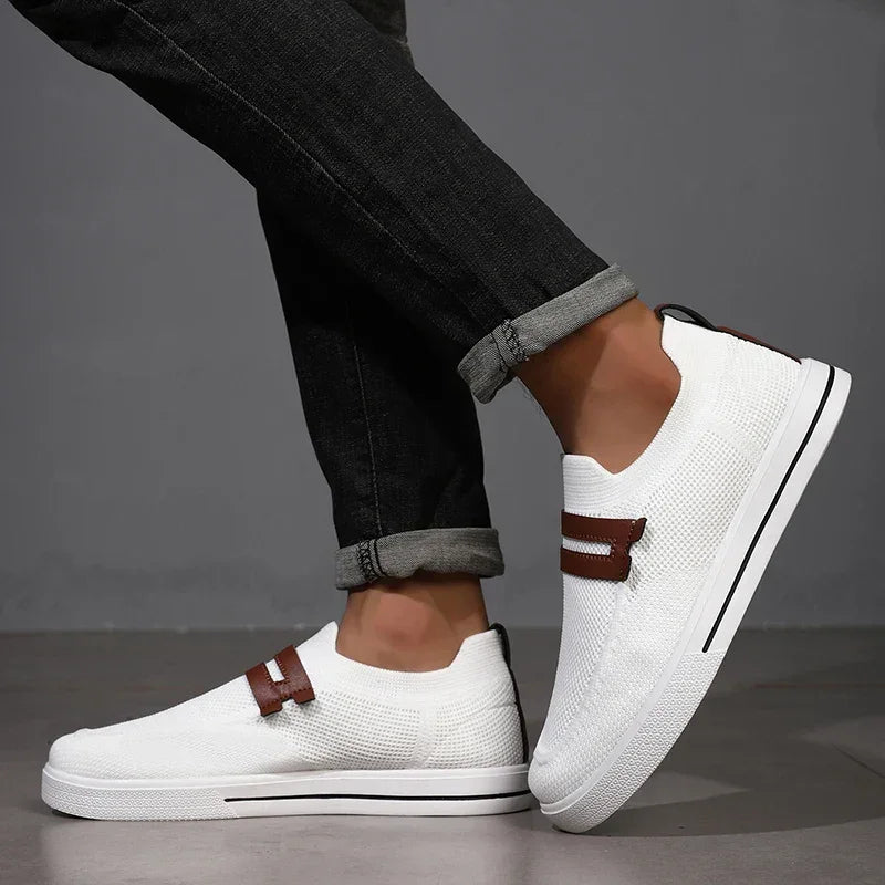 Rovelli white slip-on sneakers with brown strap detail, worn with cuffed black jeans