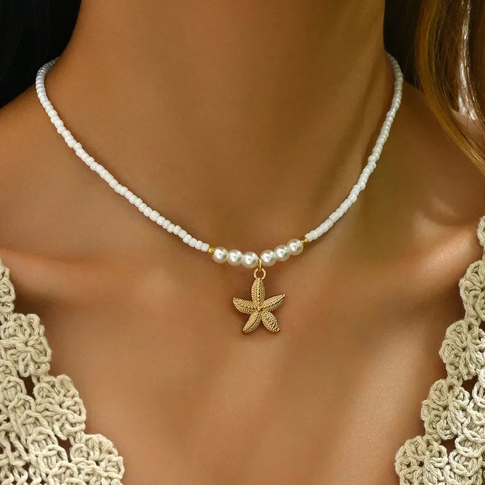 Woman wearing pearl beaded choker with gold starfish pendant, Rovelli jewelry