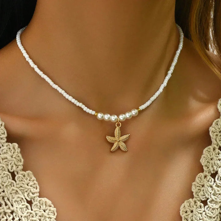 Woman wearing pearl beaded choker with gold starfish pendant, Rovelli jewelry