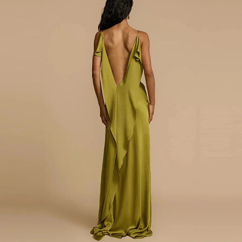 Woman in an elegant olive green backless maxi dress by Rovelli, beige background