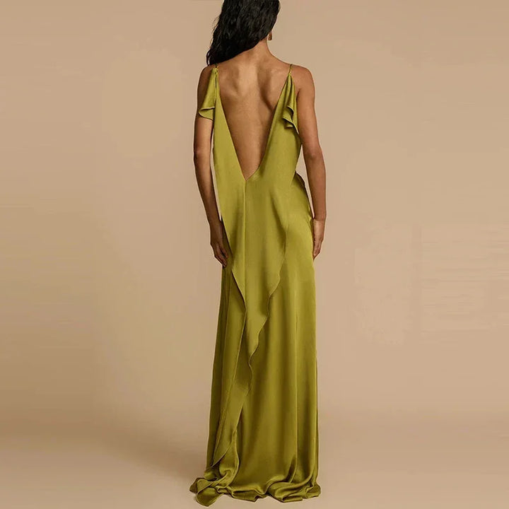 Woman in an elegant olive green backless maxi dress by Rovelli, beige background