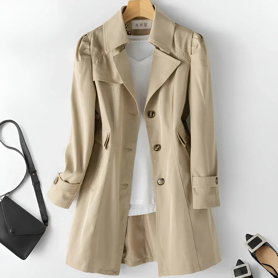 Beige trench coat with white top, black crossbody bag, and black buckle heels from Rovelli