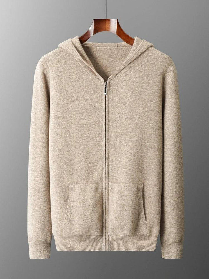 A beige zip-up hoodie with front pockets and a hood, displayed on a wooden hanger against a gray background, perfect as an autumn winter sweater for effortless men's casual cardigan style.
