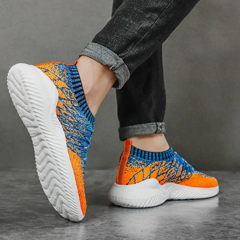 Rovelli orange and blue knit sneakers with white soles worn by model in rolled jeans