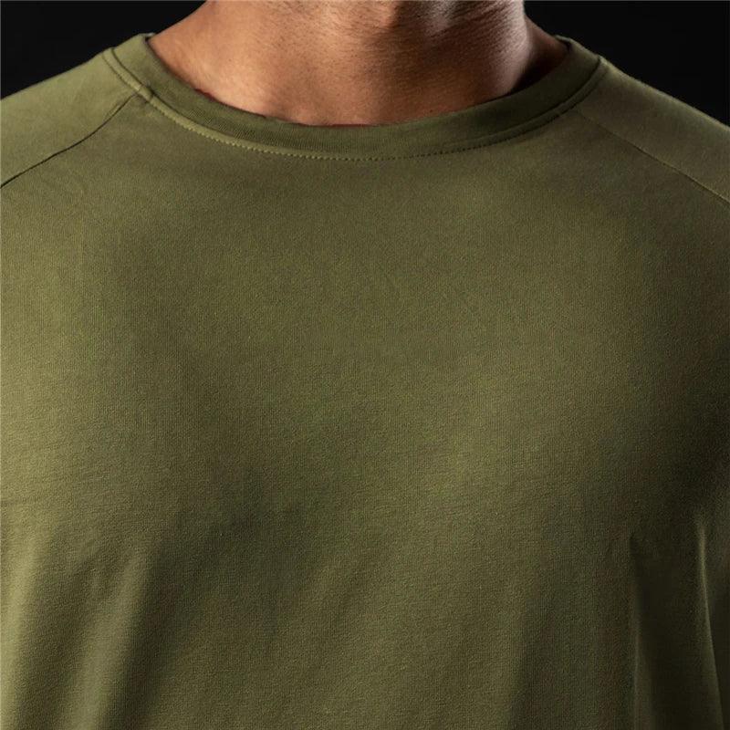 Close-up of a person wearing an olive green moisture-wicking shirt, with only the neck, shoulders, and upper chest visible against a dark background.