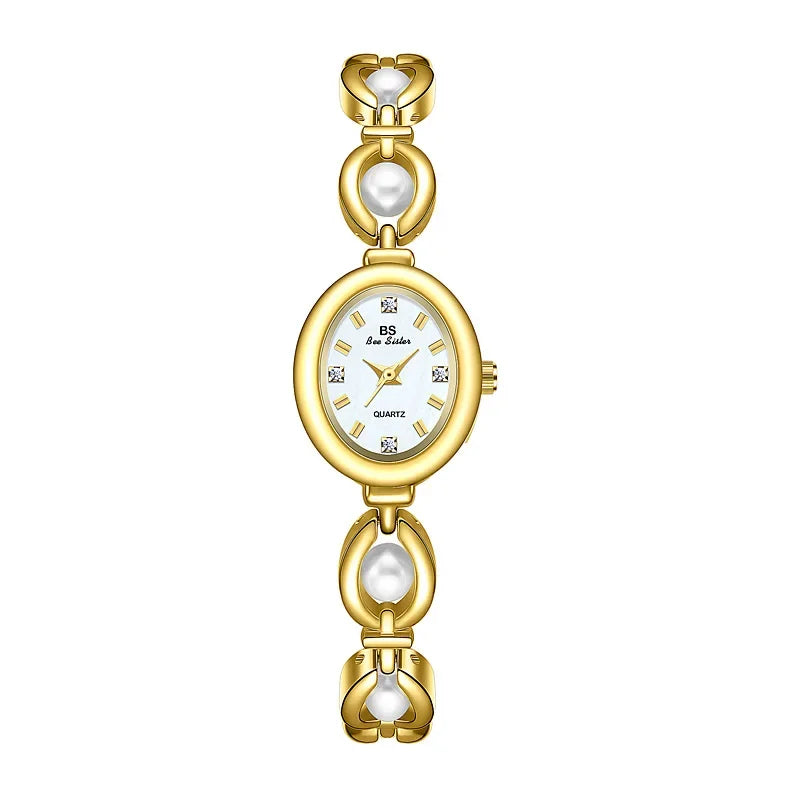 A gold-tone women’s wristwatch with an oval white face, diamond-like hour markers, and a bracelet-style band featuring gold links and elegant pearl accents.