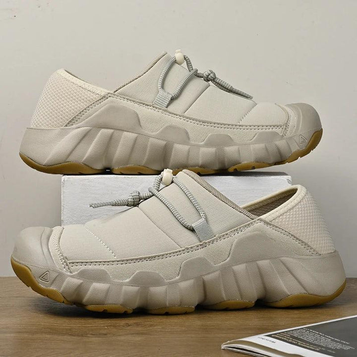 Rovelli beige slip-on sneakers with chunky sole and drawstring laces on wood surface
