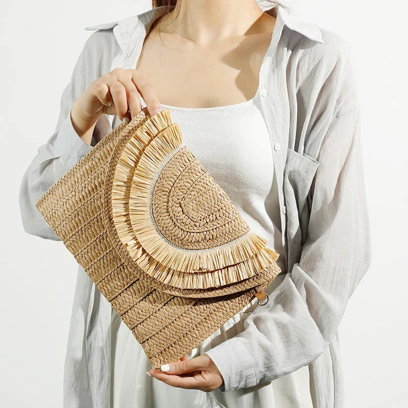 Woman holding woven straw clutch bag with fringe, Rovelli fashion accessory