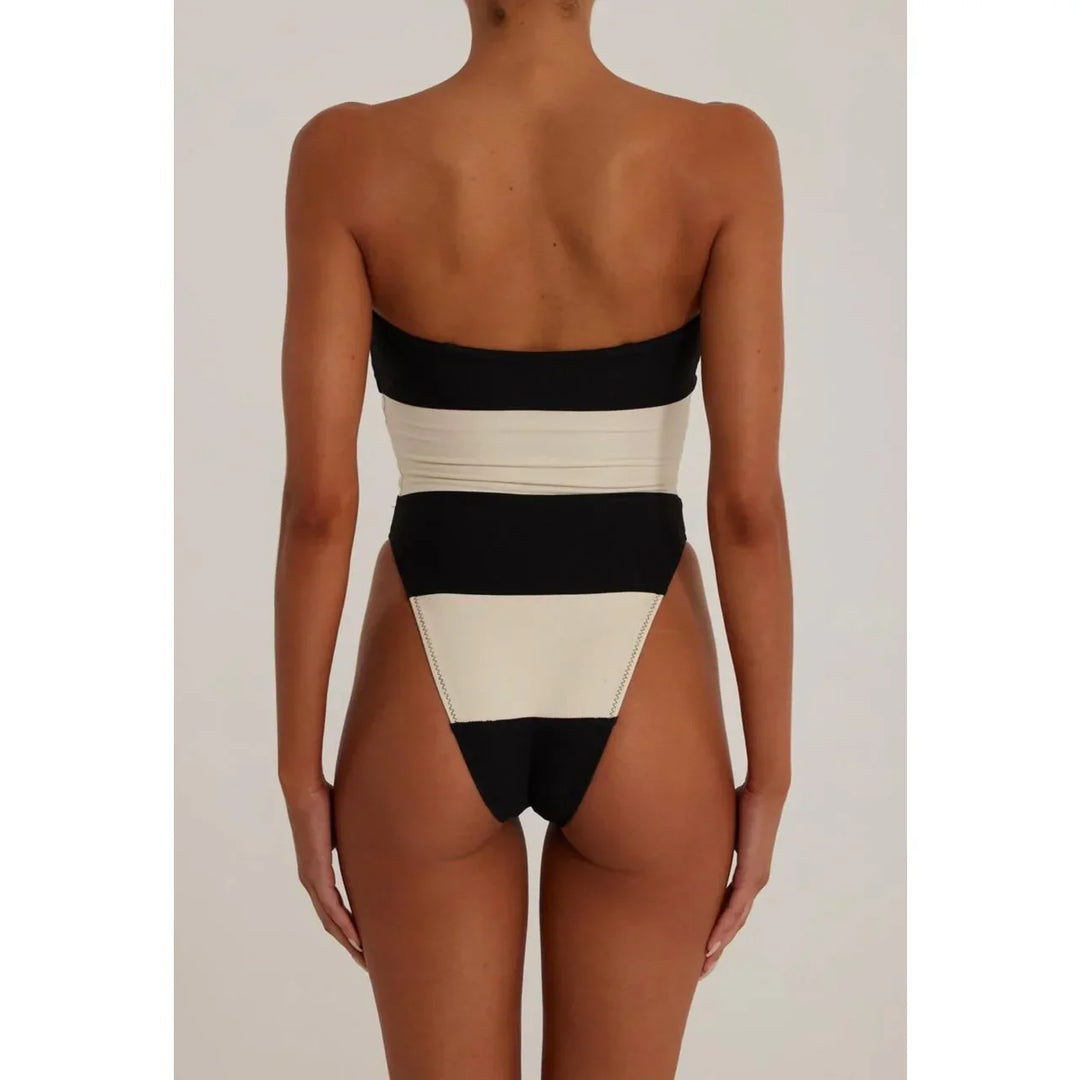 Back view of woman in black and white strapless one-piece swimsuit, Rovelli fashion