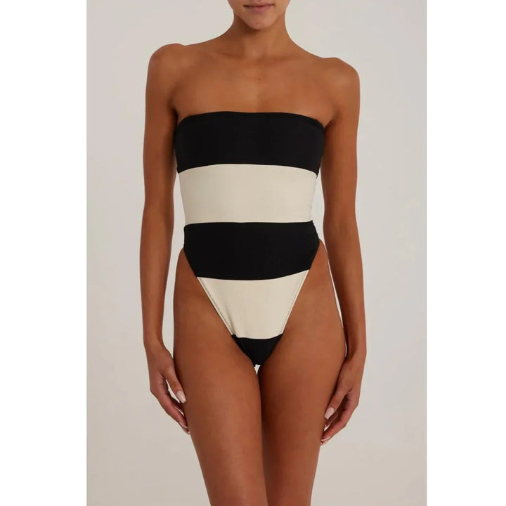 Woman wearing a black and white striped strapless one-piece swimsuit, Rovelli fashion