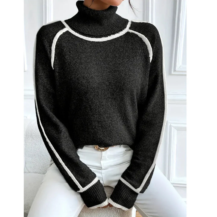 Woman wearing black turtleneck sweater with white trim and white pants, Rovelli fashion