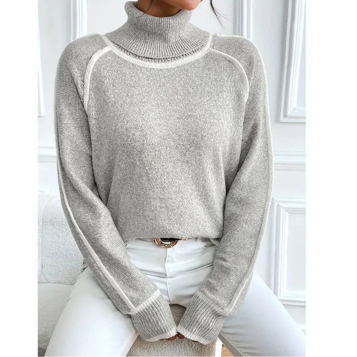 Woman wearing a light gray turtleneck sweater and white pants, Rovelli fashion style