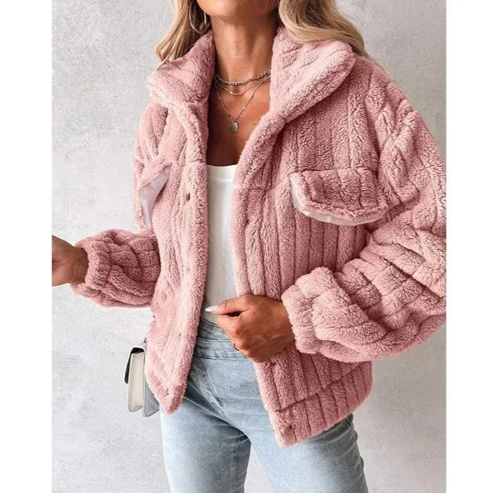 Woman wearing a pink faux fur jacket, white top, and light jeans from Rovelli