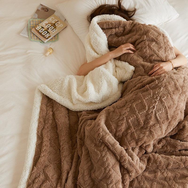 Brown sherpa fleece blanket by Rovelli on bed, person relaxing under cozy textured throw