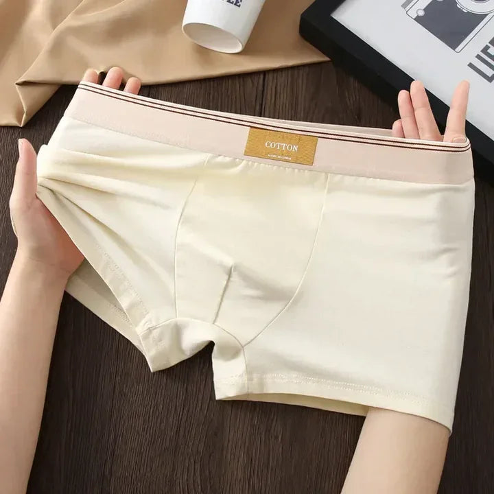 Rovelli cream cotton men's boxer briefs stretched by hands on dark wooden table