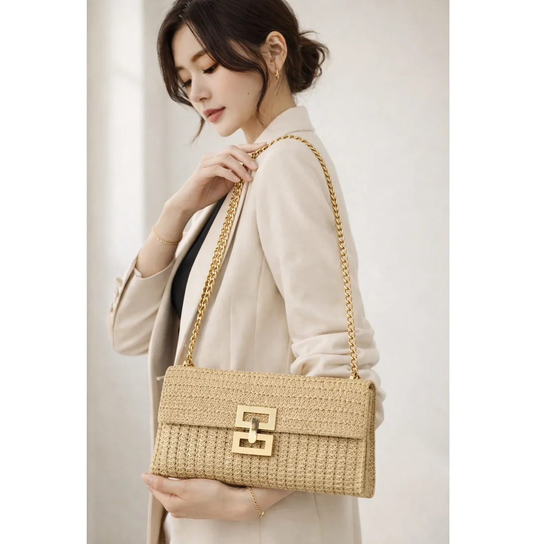 Woman in beige blazer with Rovelli woven shoulder bag and gold chain strap