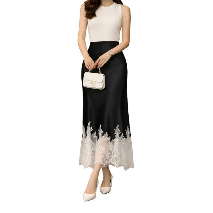 Elegant sleeveless dress with black skirt, lace hem, white top, and chic purse by Rovelli