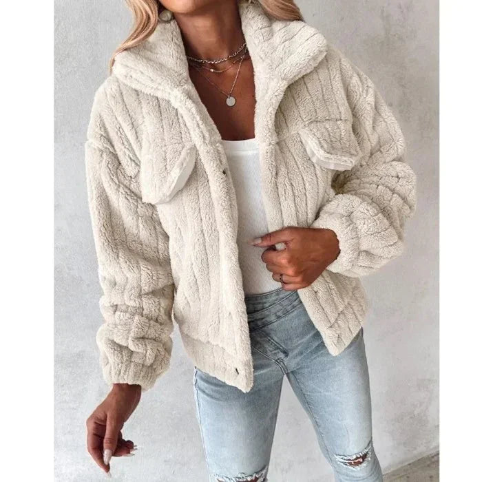 Woman wearing a cream faux fur jacket, white top, and light blue jeans, Rovelli fashion