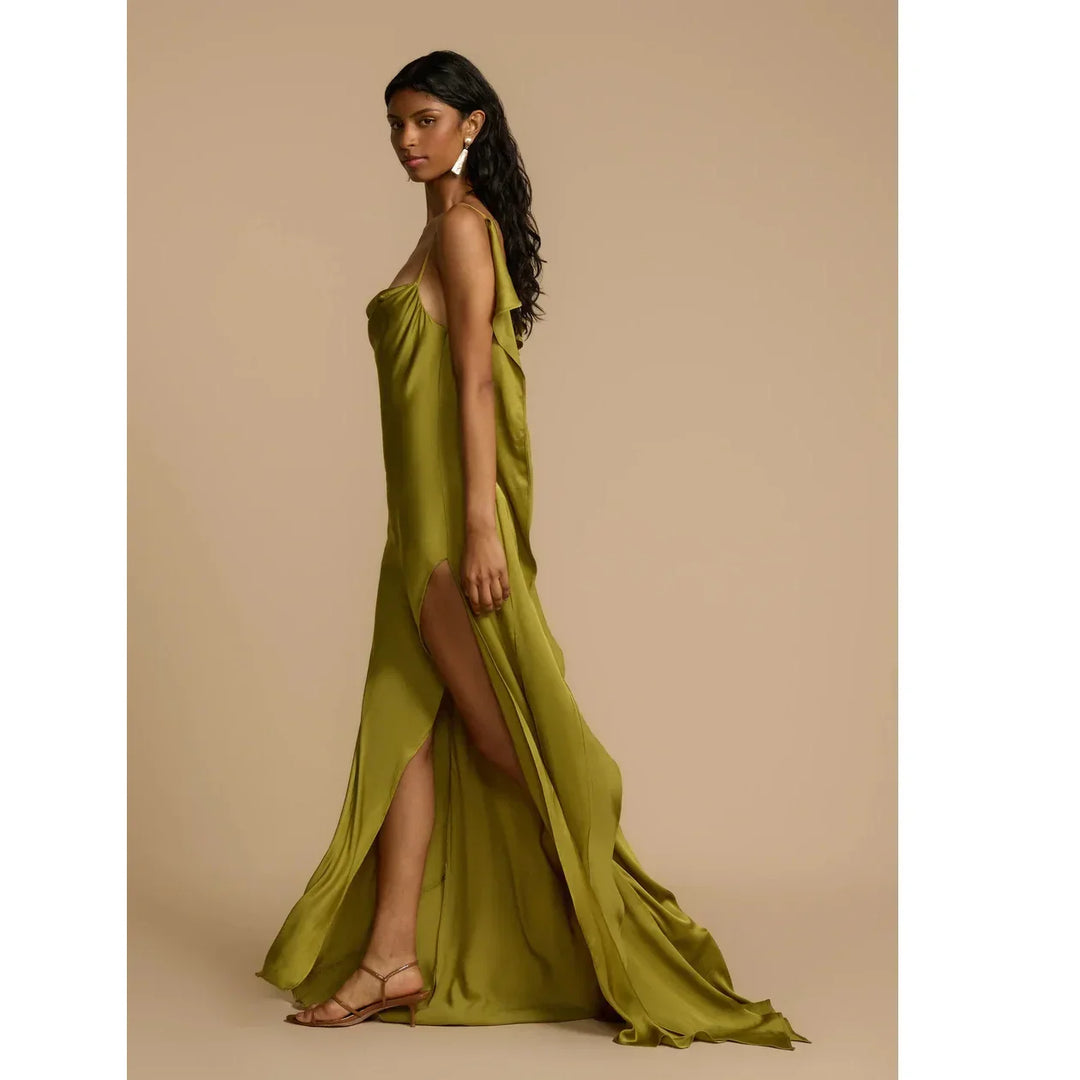 Woman modeling olive green satin Odessa dress by Rovelli with side slit, neutral backdrop