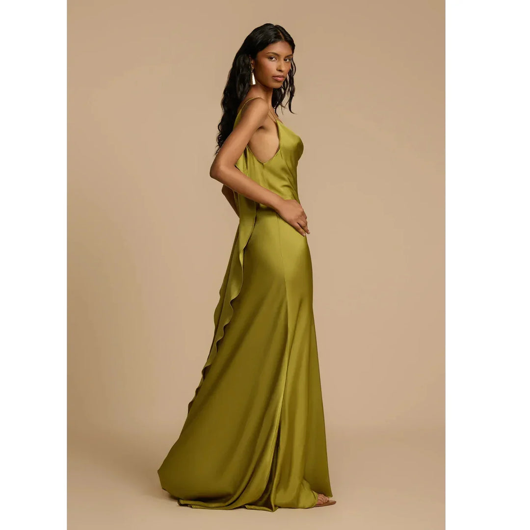 Woman in olive green satin Rovelli Odessa dress with ruffled side, studio background